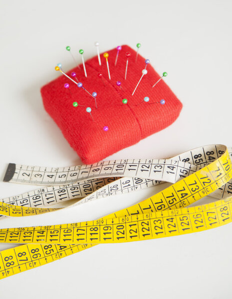 Pincushion And Measure Tape On Table At Factory