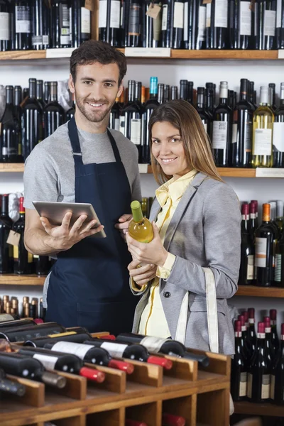 Vendeur tenant tablette numérique tandis que le client avec bouteille de vin — Photo