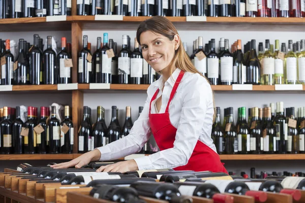 Verkoopster schikken wijnflessen In Rack — Stockfoto