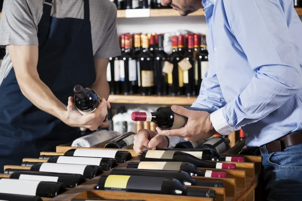 Venditore Assistere il cliente nella selezione di bottiglia di vino a Supermar — Foto Stock