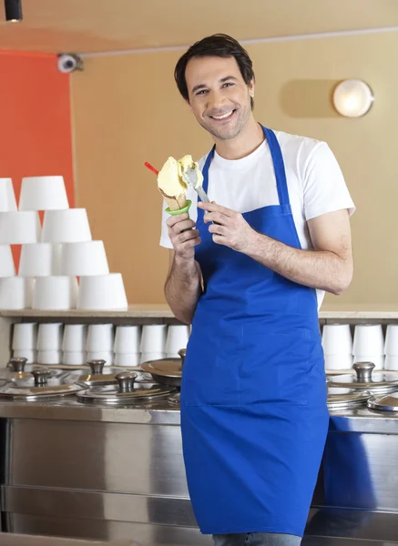 Χαρούμενος σερβιτόρος αρσενικό προετοιμασία παγωτό στο σαλόνι — Φωτογραφία Αρχείου