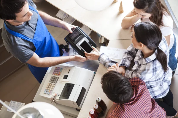 Femme avec la famille effectuant le paiement avec la technologie de NFC — Photo