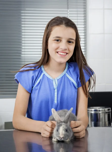 Sorrindo menina bonito com coelho na clínica — Fotografia de Stock