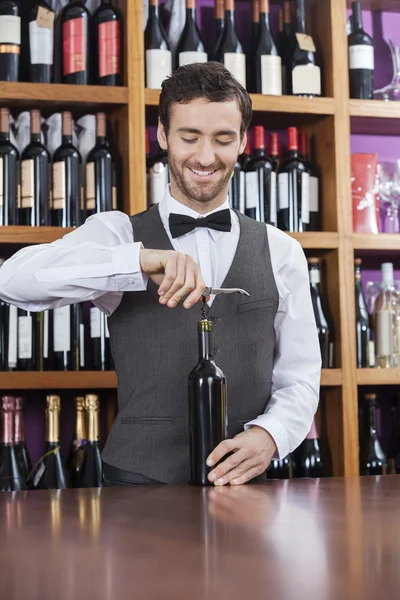 Barman utilisant tire-bouchon pour ouvrir la bouteille de vin — Photo