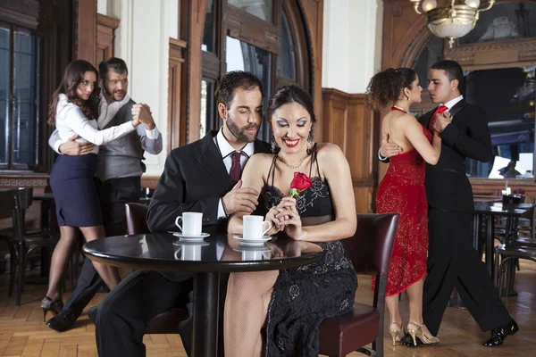 Šťastný pár s úsměvem a růže, zatímco těší Tango výkon — Stock fotografie