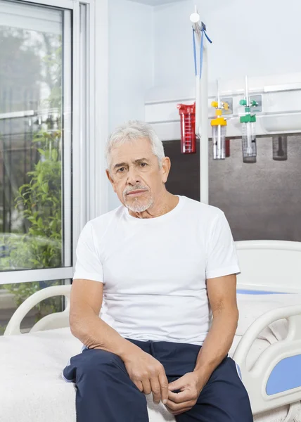 Yatakta Rehabilitasyon merkezinde oturan düşünceli üst düzey adam — Stok fotoğraf