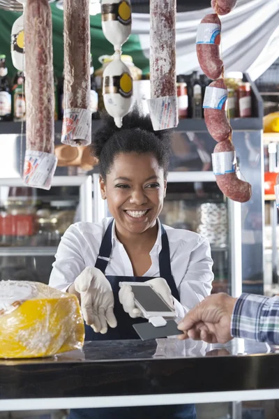 Vendedora feliz aceptando el pago del cliente — Foto de Stock