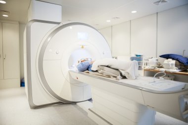 Female Patient Going Through MRI Scan In Hospital clipart
