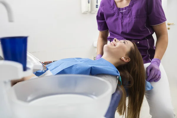 Zufriedener Patient schaut Zahnarzt im Sitzen an — Stockfoto