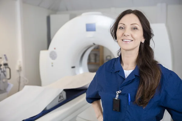 Vrouwelijke professionele glimlachend tegen Mri-Machine — Stockfoto