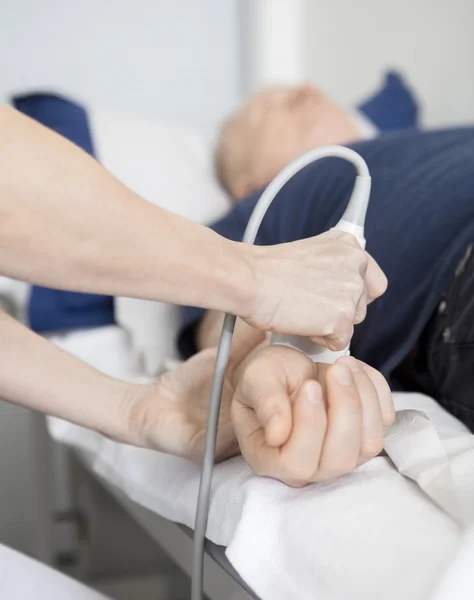 Imagem recortada do médico usando sonda de ultra-som no pulso dos homens — Fotografia de Stock