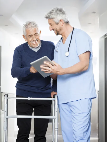 Fyzioterapeut, zobrazení sestav v tabletovém počítači se starší muž — Stock fotografie