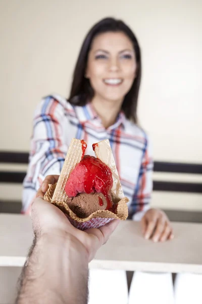 Main donnant de la crème glacée dans un bol à gaufres au client féminin — Photo