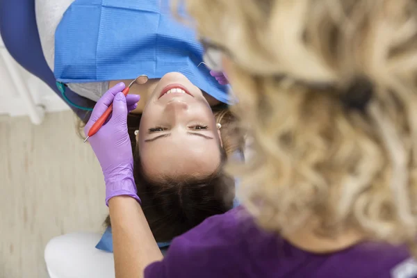 Paciente sendo examinado por dentista segurando espelho dentário — Fotografia de Stock