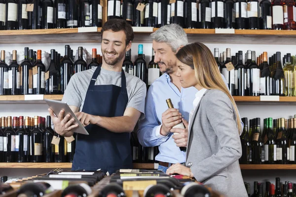 Vendedor que mostra a informação do vinho aos clientes na tabuleta digital — Fotografia de Stock