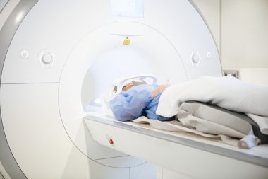 Hastayı MRI tarama sırasında baş bobin giyiyor