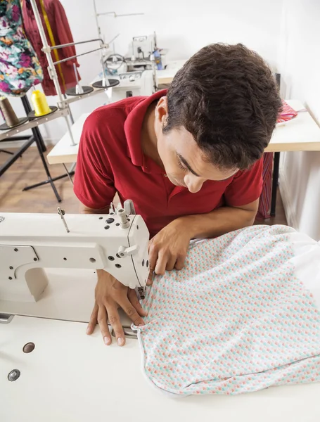 Skräddaren sy tyg på arbetsbänk i fabrik — Stockfoto