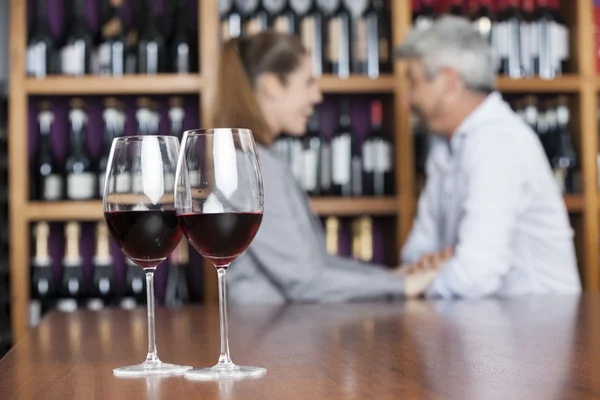 Vino tinto en vasos con pareja en segundo plano — Foto de Stock