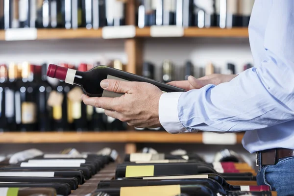 Midsection of Customer Holding Wine Bottle — стоковое фото