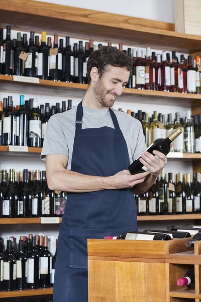 Salesman Reading Label Of Wine Bottle In Store — Stock Photo, Image