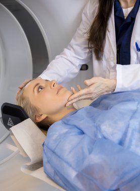 Midsection bir doktor hasta yüzü daha önce MRI tarama ayarlama