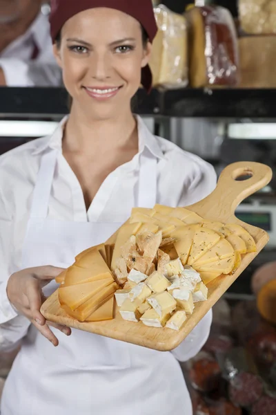 Saleswoman Holding Cutting Board With Various Cheese — Stock Photo, Image