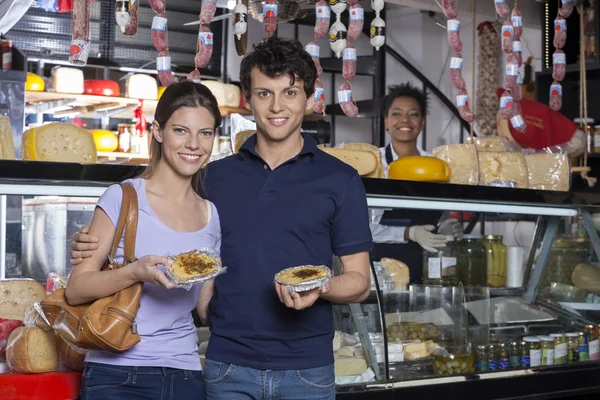 Happy Young Couple Holding Cheese At Grocery Store — Stock Photo, Image