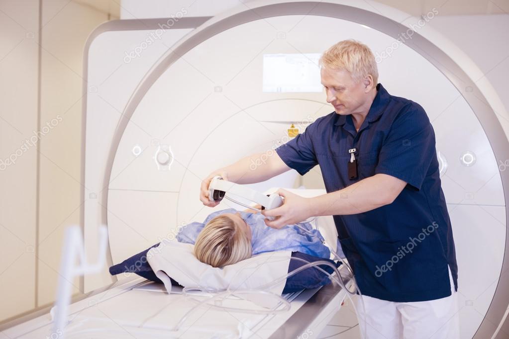 Radiologist Putting Headphones On Female Patient