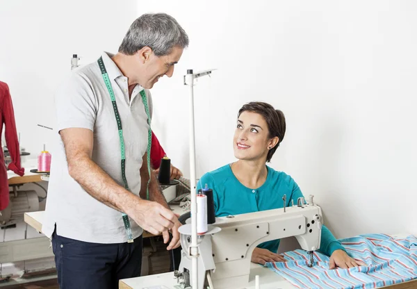 Skräddare diskuterar på arbetsbänk i sömnad Factory — Stockfoto