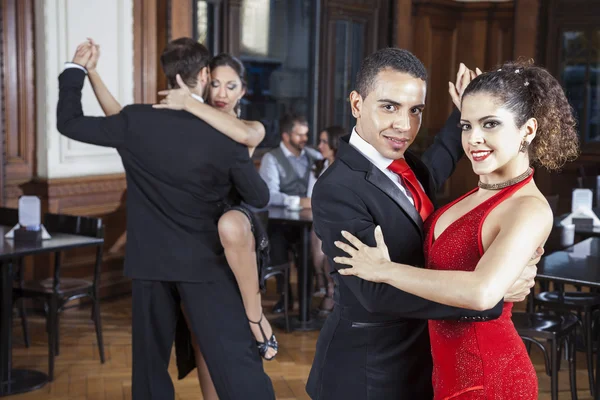 Uomo e donna fiduciosi che eseguono tango nel ristorante — Foto Stock