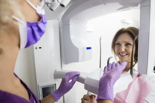 Sonriente paciente usando máquina de rayos X — Foto de Stock