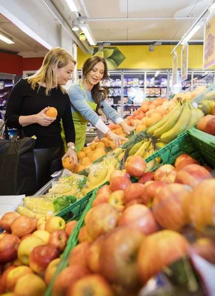 Cliente e vendedora escolhendo frutas frescas — Fotografia de Stock