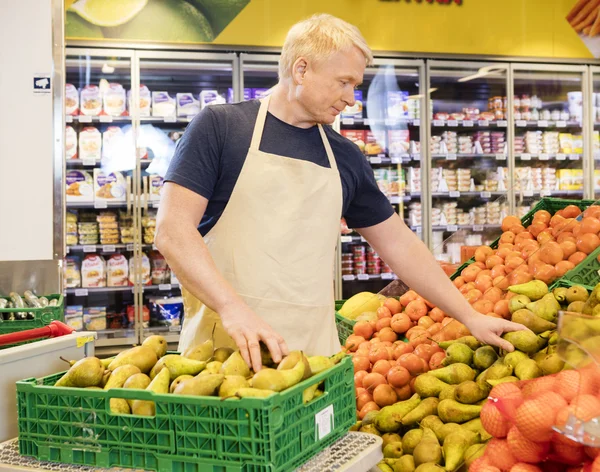 Självsäker försäljare att arrangera färska päron — Stockfoto