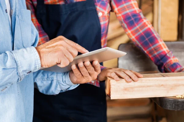 Carpinteros masculinos y femeninos usando tableta digital — Foto de Stock