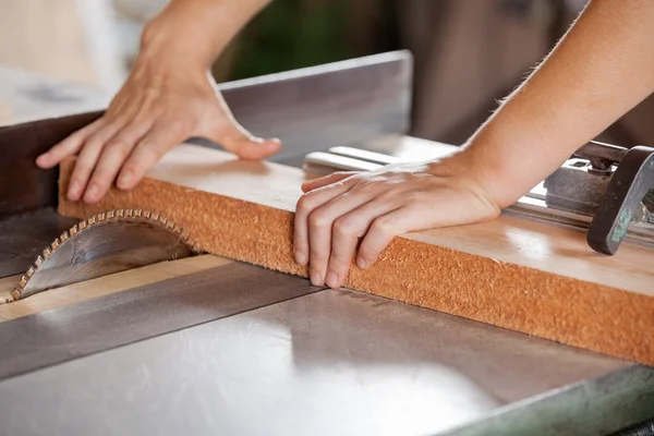 Timmerlieden handen snijden van hout met tablesaw — Stockfoto