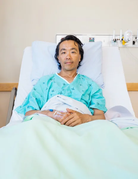 Paciente masculino reclinado na cama no hospital — Fotografia de Stock
