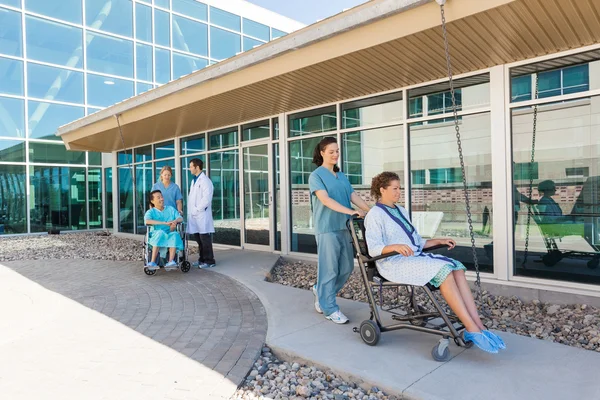 Medicinska teamet med patienter på rullstolar på sjukhuset courtyard — Stockfoto