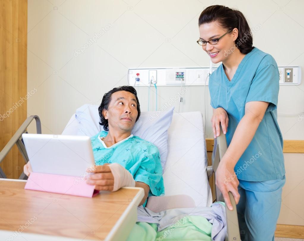 Nurse And Male Patient Using Digital Tablet