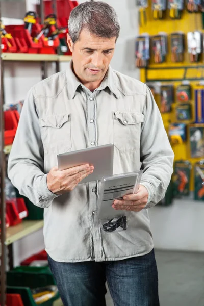 Analisando o produto através do tablet digital — Fotografia de Stock