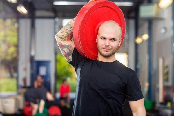 Man hijs barbell plaat — Stockfoto