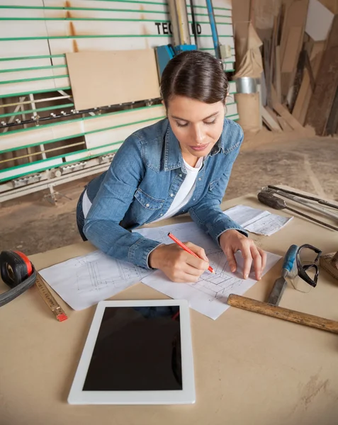 Carpinteiro Feminino Trabalhando em Blueprint Em Workshop — Fotografia de Stock