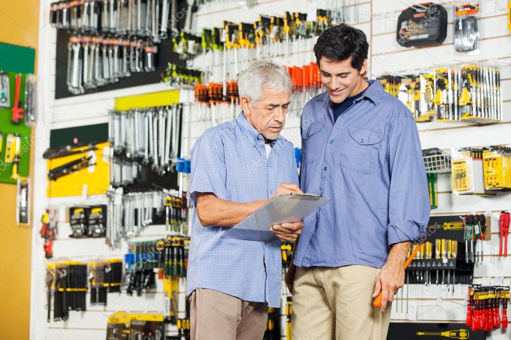 Father And Son Checking Checklist In Hardware Store