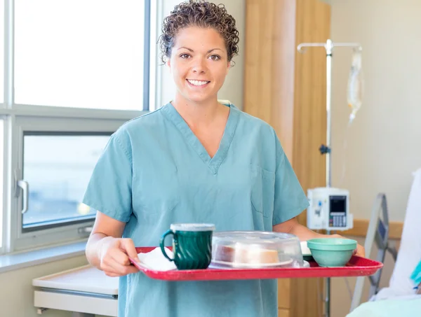 Enfermera sosteniendo bandeja de desayuno en la habitación del hospital — Foto de Stock