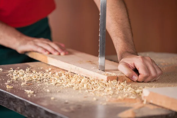 Carpinteiros mãos cortando madeira com serra de fita — Fotografia de Stock