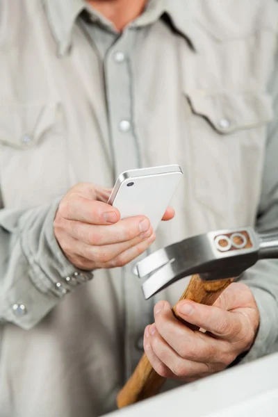 Man scanning hammer genom smartphone — Stockfoto