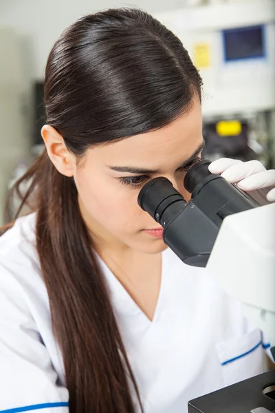 Cientista feminina olhando através do microscópio — Fotografia de Stock