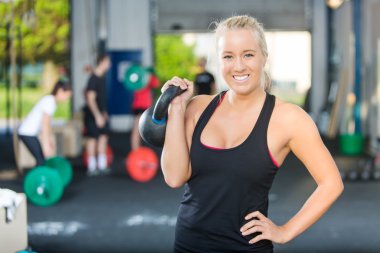 mutlu kadın atlet kaldırma kettlebell