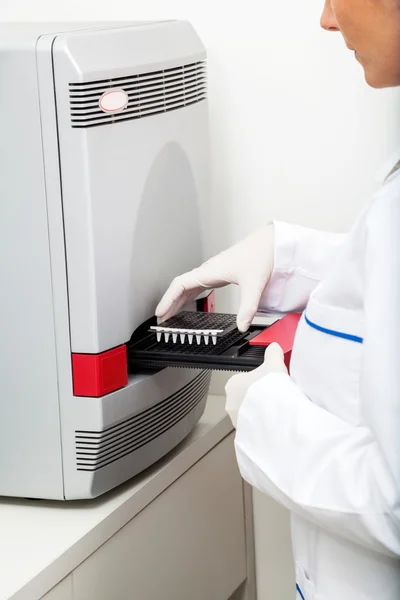 Naukowiec wprowadzania próbki w maszynie — Zdjęcie stockowe