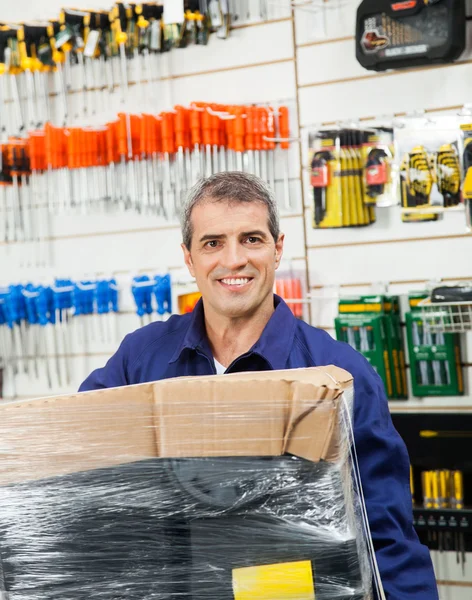 Trabajador con paquete envuelto en la tienda de hardware —  Fotos de Stock