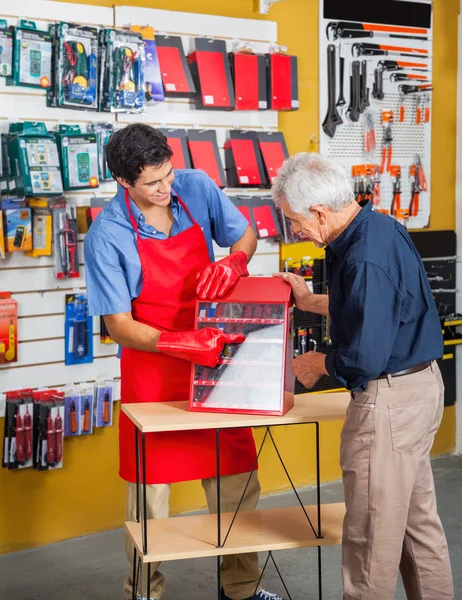 Prodavač vedení člověka při výběru nástrojů v obchodě — Stock fotografie